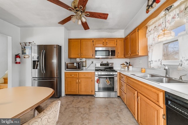 kitchen with a ceiling fan, a sink, light countertops, appliances with stainless steel finishes, and brown cabinets