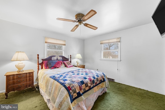 carpeted bedroom with visible vents, multiple windows, baseboards, and ceiling fan