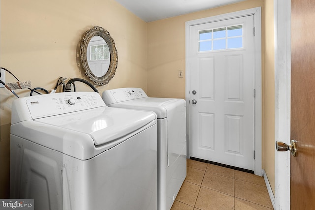 clothes washing area with washing machine and clothes dryer, laundry area, and light tile patterned flooring