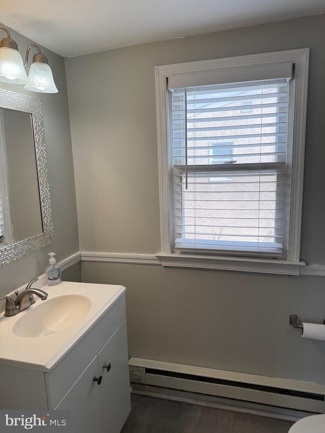 half bathroom with baseboard heating and vanity