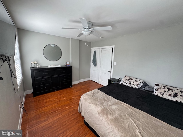 bedroom featuring baseboards, wood finished floors, and a ceiling fan