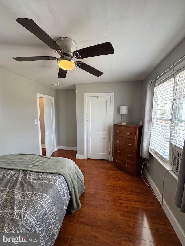 bedroom featuring a ceiling fan, baseboards, dark wood-style flooring, and a closet