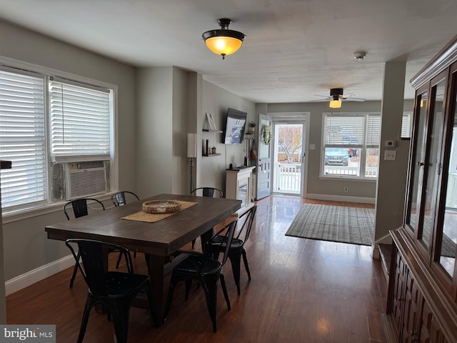 dining space featuring ceiling fan, cooling unit, baseboards, and wood finished floors