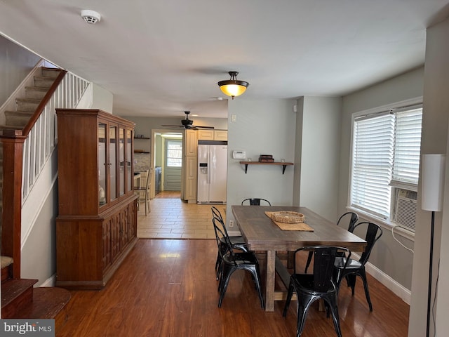 dining room with stairway, baseboards, light wood-type flooring, and ceiling fan