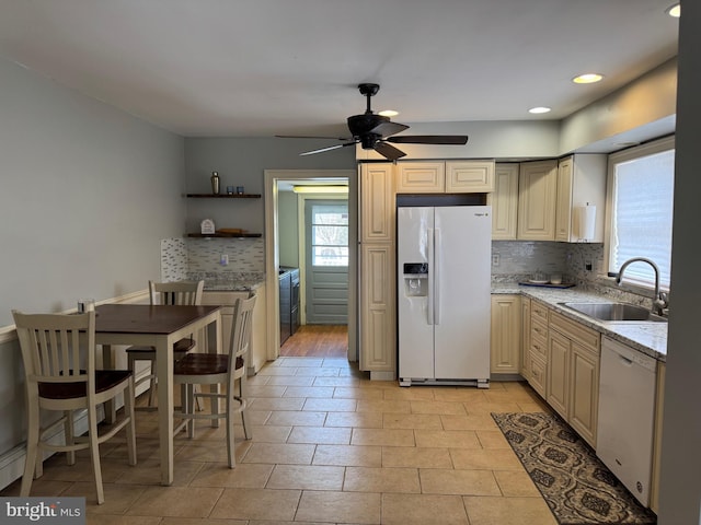 kitchen with a sink, open shelves, light stone counters, white appliances, and decorative backsplash