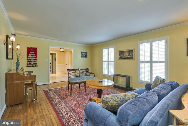 living area featuring hardwood / wood-style flooring, baseboards, and ornamental molding