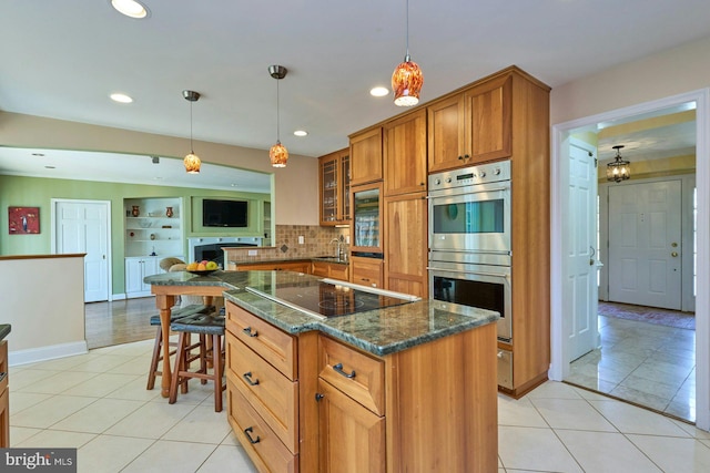 kitchen featuring glass insert cabinets, brown cabinetry, black electric stovetop, light tile patterned flooring, and stainless steel double oven