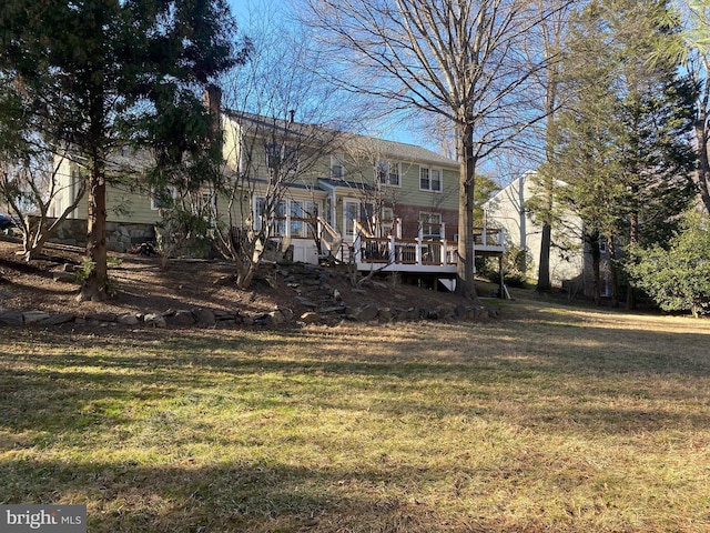 rear view of property with a deck and a yard