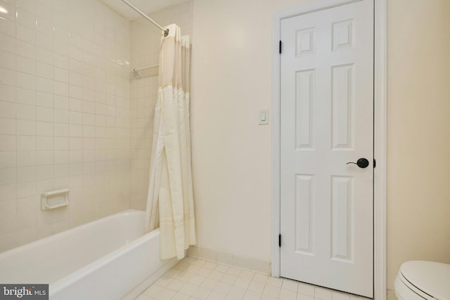 bathroom with baseboards, toilet, shower / bath combination with curtain, and tile patterned flooring