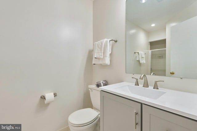 bathroom with a stall shower, toilet, and vanity