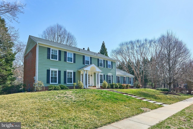 view of front facade with brick siding and a front yard