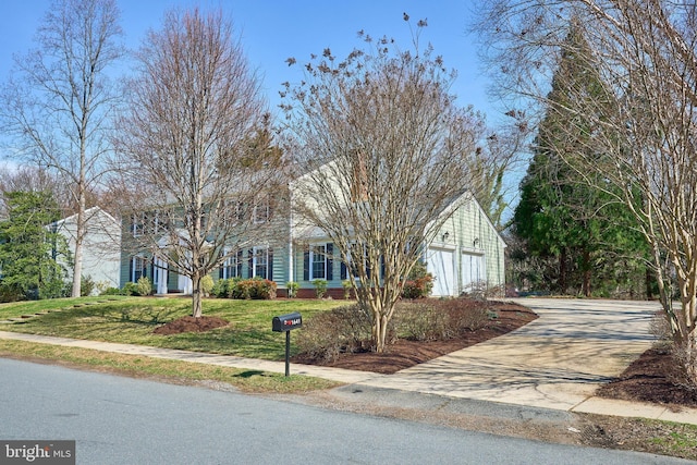 view of front of property featuring driveway, a front lawn, and an attached garage