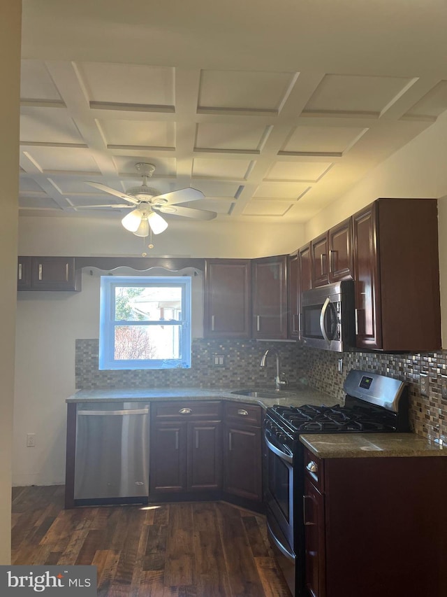 kitchen featuring dark wood-style floors, backsplash, stainless steel appliances, and a sink