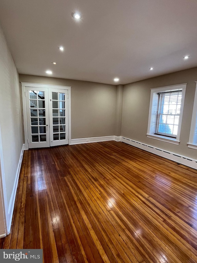 unfurnished room with baseboards, a baseboard radiator, hardwood / wood-style floors, french doors, and recessed lighting