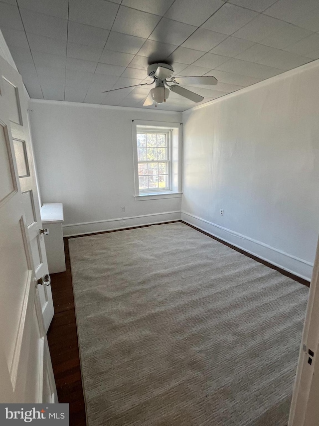 spare room with a ceiling fan, crown molding, and baseboards