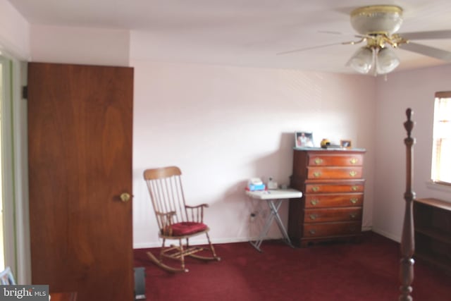 living area with baseboards, carpet, and a ceiling fan