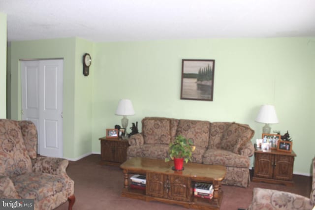 carpeted living area with baseboards