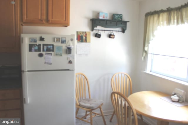 kitchen featuring brown cabinetry and freestanding refrigerator