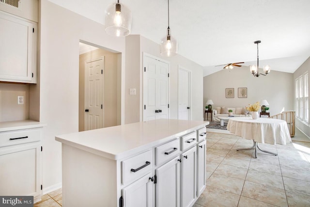 kitchen featuring pendant lighting, open floor plan, white cabinets, light countertops, and lofted ceiling