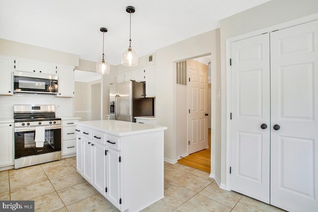 kitchen featuring white cabinetry, light countertops, backsplash, and stainless steel appliances