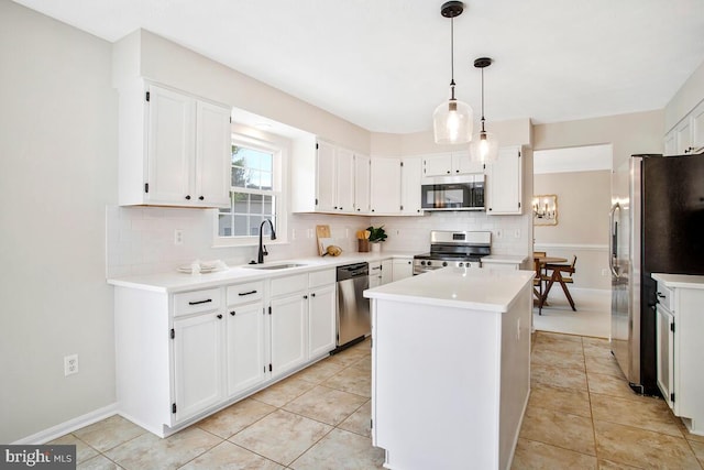 kitchen featuring a sink, tasteful backsplash, a kitchen island, white cabinetry, and stainless steel appliances