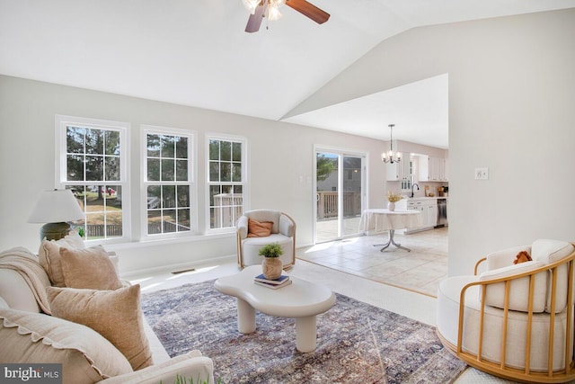 living area featuring light tile patterned floors, visible vents, ceiling fan with notable chandelier, and lofted ceiling