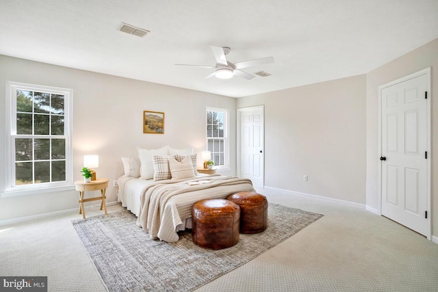 carpeted bedroom with multiple windows, baseboards, and visible vents