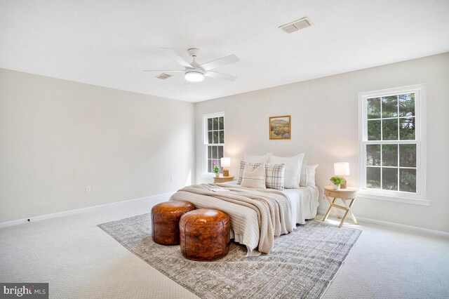 carpeted bedroom featuring visible vents, a ceiling fan, and baseboards