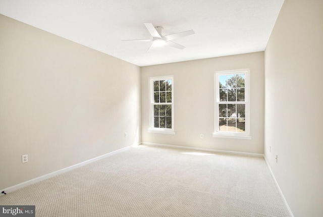 carpeted empty room featuring baseboards and ceiling fan