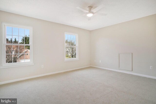 empty room with ceiling fan, baseboards, and light carpet