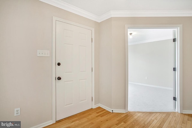 entryway featuring light wood-type flooring, baseboards, and crown molding