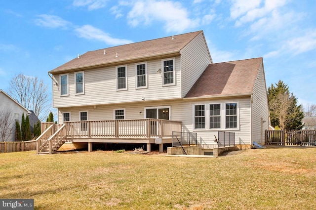 rear view of house with fence, a lawn, and a wooden deck