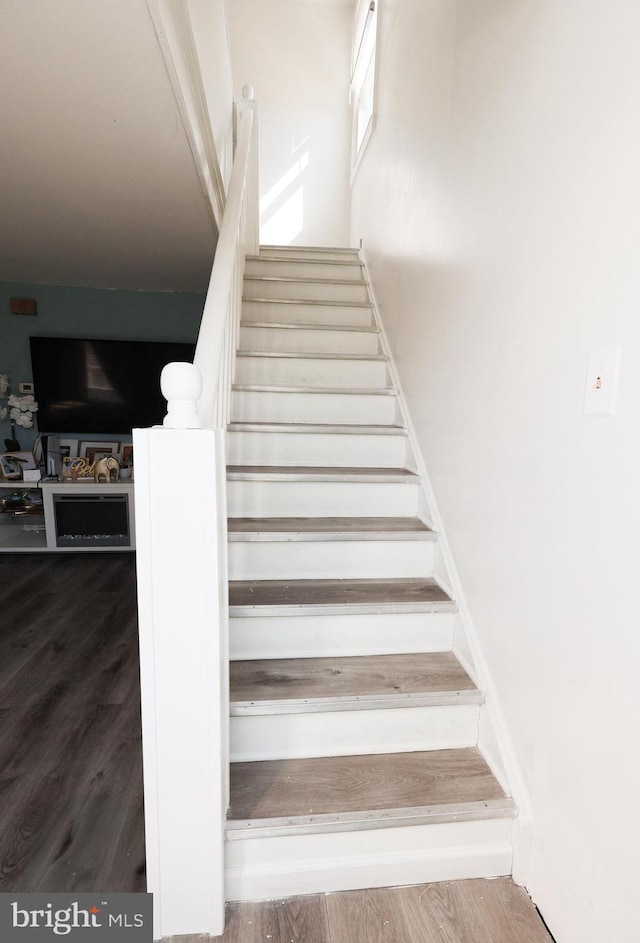 stairs featuring wood finished floors