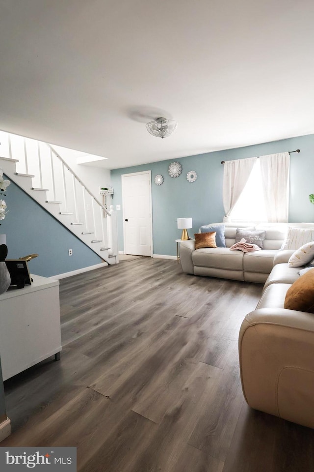 living area featuring stairway, wood finished floors, and baseboards