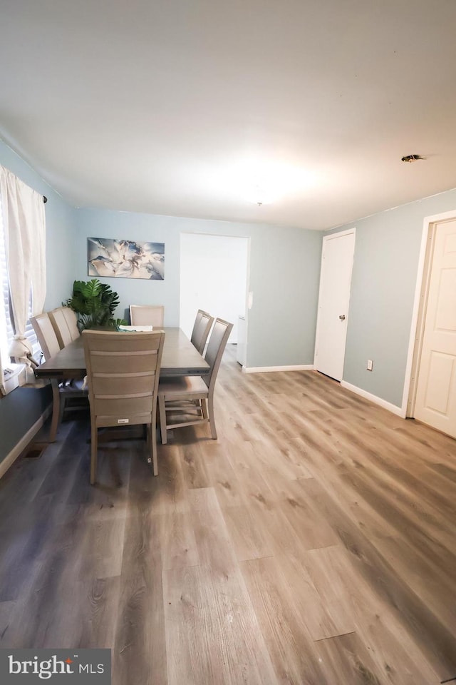 dining room with baseboards and light wood-style flooring