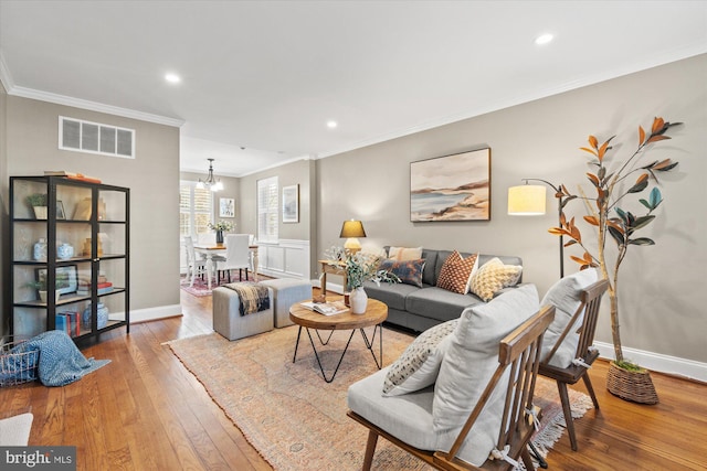 living area featuring visible vents, crown molding, baseboards, and hardwood / wood-style floors