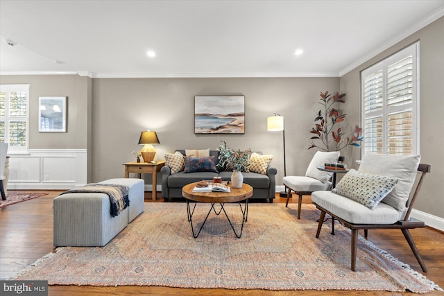 living area with recessed lighting, a wainscoted wall, wood-type flooring, and ornamental molding