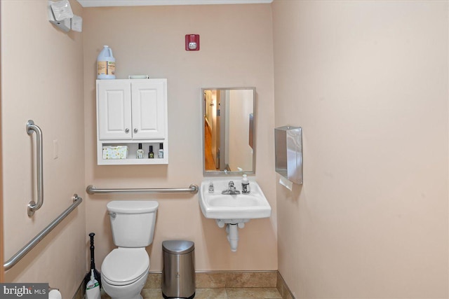 bathroom with tile patterned floors, baseboards, toilet, and a sink