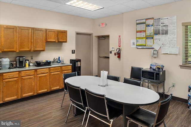 kitchen with stainless steel microwave, brown cabinetry, light countertops, and a sink