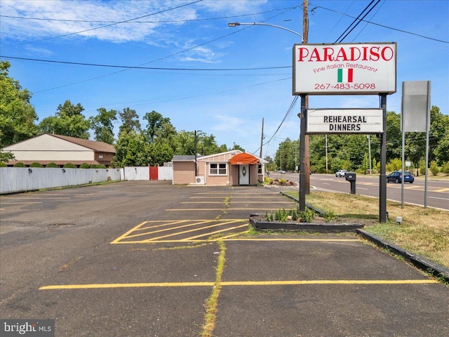 uncovered parking lot featuring fence