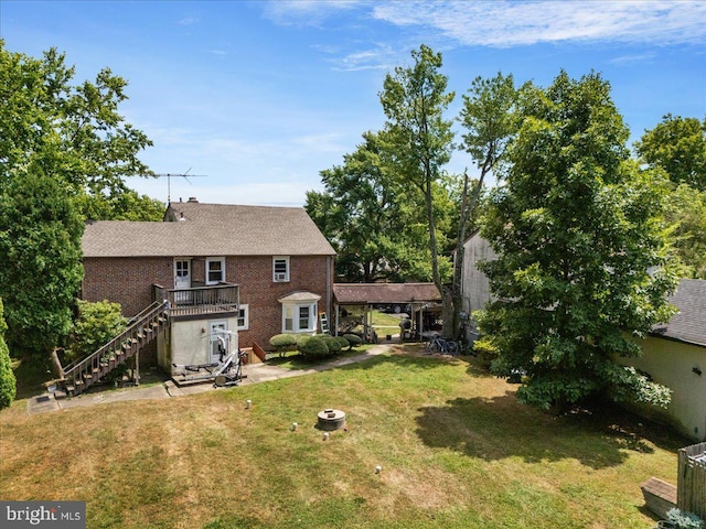 rear view of property featuring a wooden deck, brick siding, stairs, a patio area, and a lawn