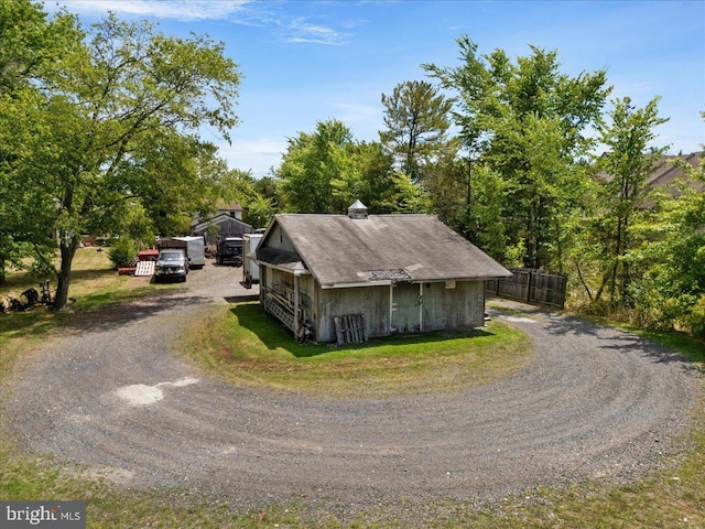 exterior space featuring dirt driveway and fence