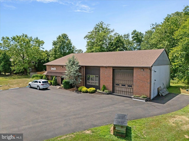 view of front of home featuring aphalt driveway, brick siding, and an attached garage