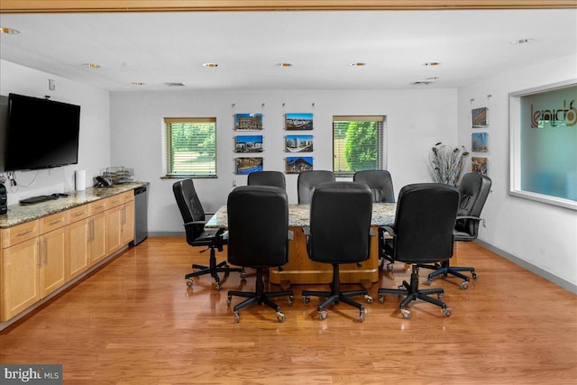 dining area with a wealth of natural light, baseboards, and light wood-style flooring