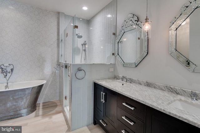 bathroom with a sink, a soaking tub, a stall shower, and double vanity