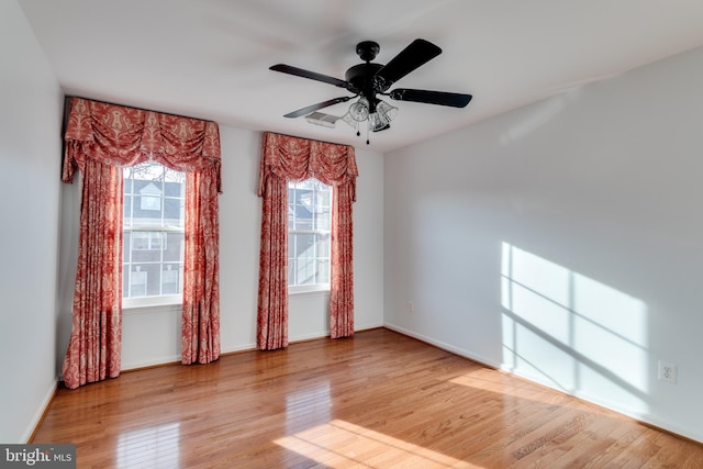 empty room featuring baseboards, wood finished floors, and a ceiling fan