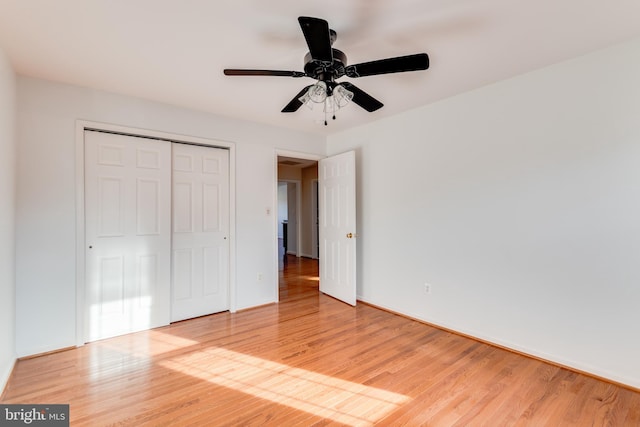 unfurnished bedroom with a closet, baseboards, light wood-style flooring, and a ceiling fan