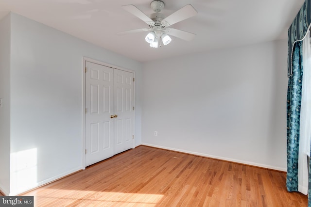 unfurnished bedroom featuring light wood-type flooring, baseboards, a closet, and ceiling fan