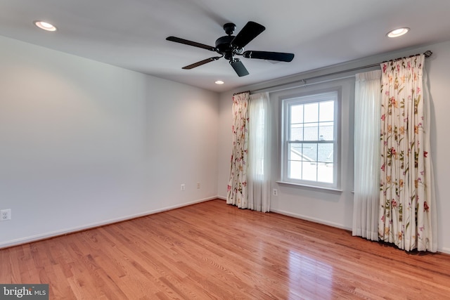 empty room featuring a ceiling fan, recessed lighting, wood finished floors, and baseboards