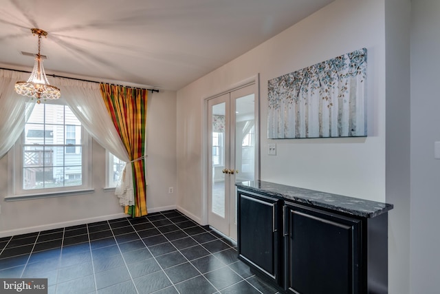 doorway featuring dark tile patterned floors, french doors, and baseboards